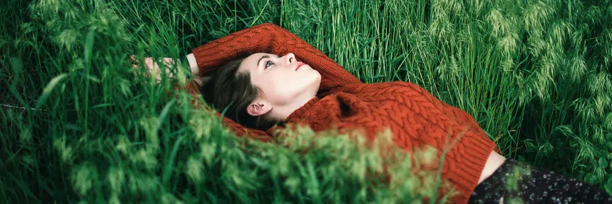 Woman lying in grass, Women with laptop, trusted bodywork, somatic healing, myofascial release, safe space for healing
